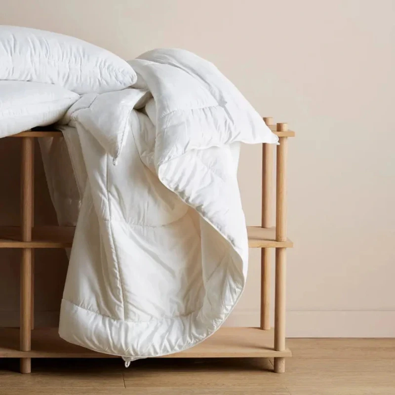 Ettitude Bamboo Comforter on a wooden bed, soft white vegan duvet for eco-friendly and hypoallergenic sleep.